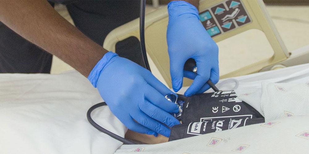 nurse's hands taking blood pressure